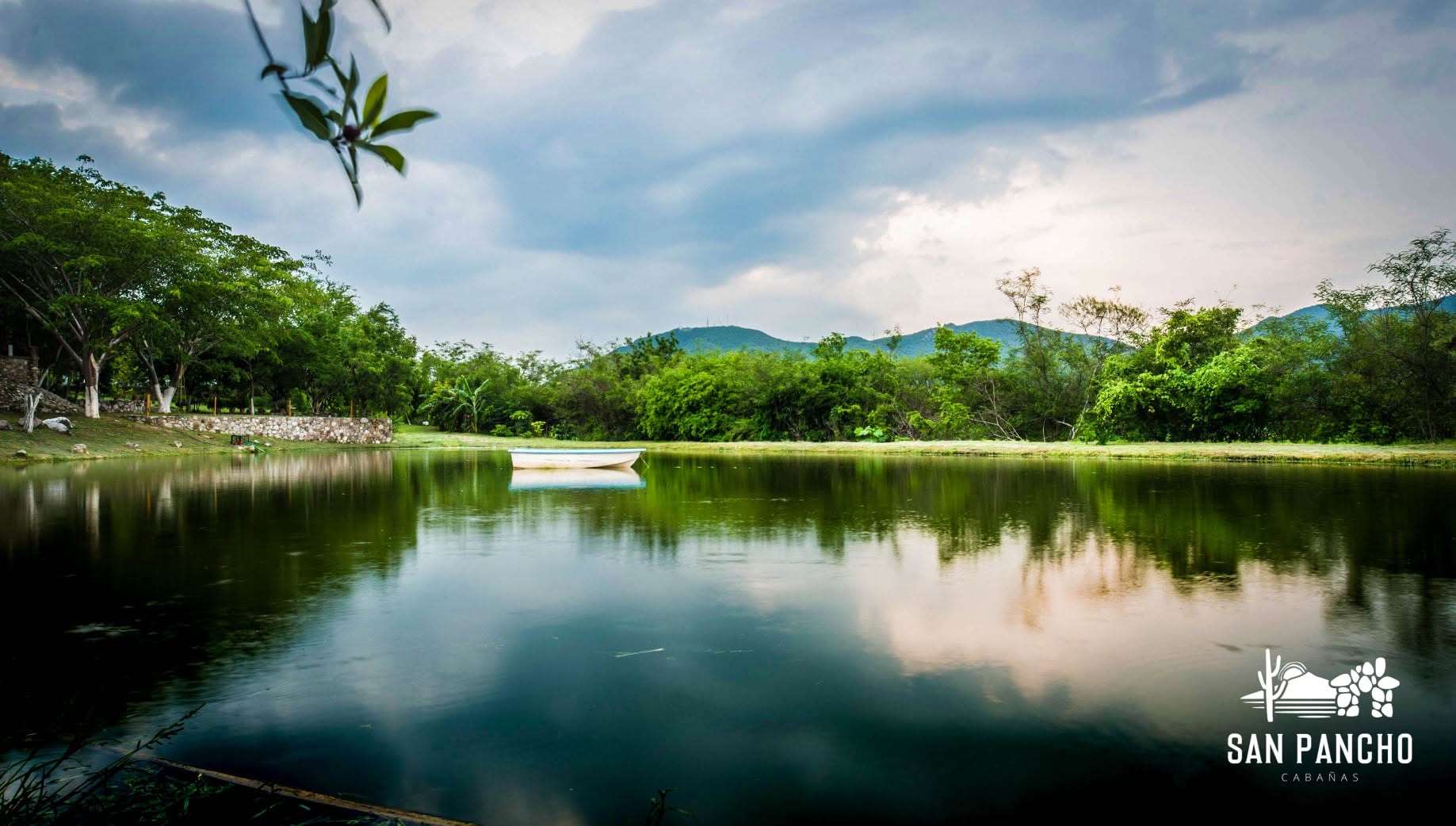 Lago de San Pancho rodeado de árboles, con una lancha en el agua